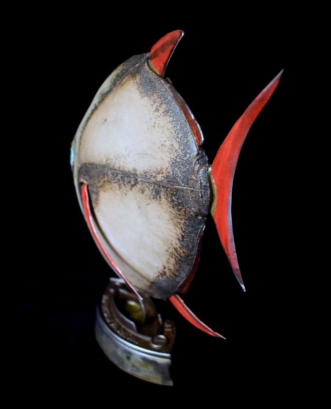 Keramikfisch auf einem antiken Eisenständer